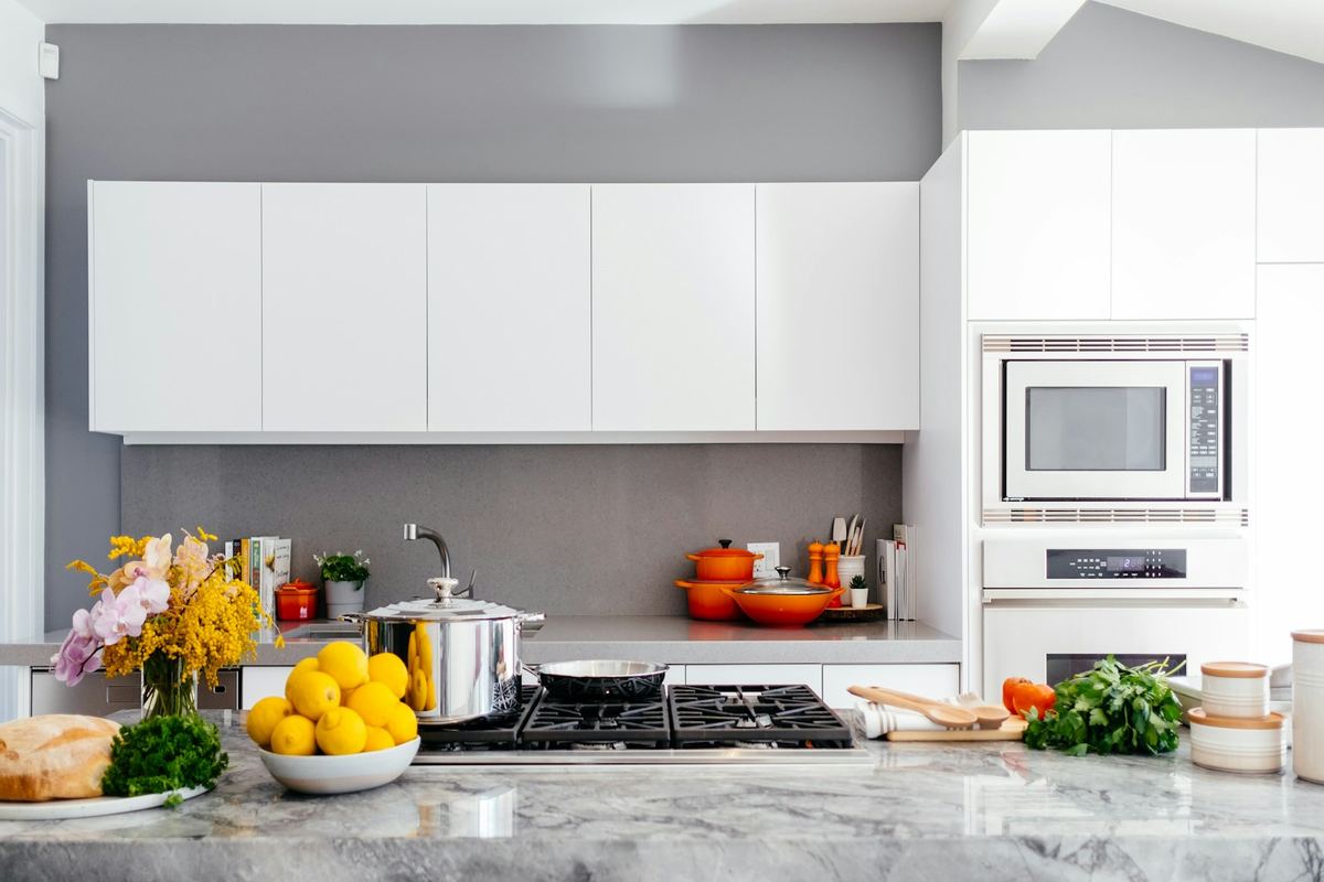 A spotless modern kitchen with a shining stove and marble counter